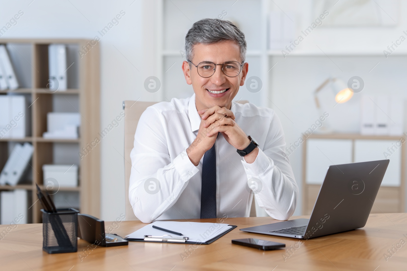 Photo of Portrait of businessman at table in office