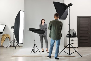 Photo of Photographer working with model in professional photo studio