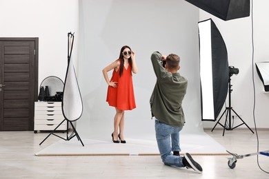 Photographer working with model in professional photo studio