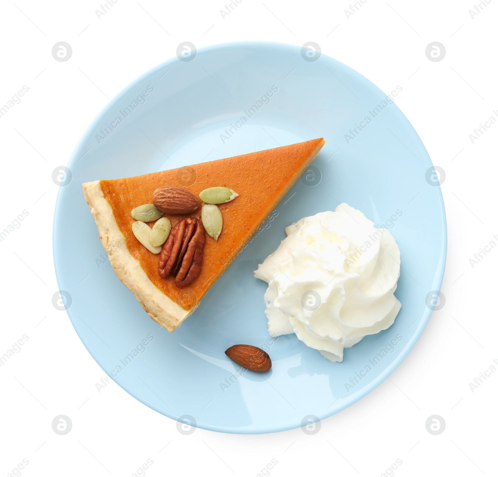 Photo of Piece of tasty homemade pumpkin pie with whipped cream, seeds and nuts isolated on white, top view