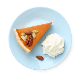 Photo of Piece of tasty homemade pumpkin pie with whipped cream, seeds and nuts isolated on white, top view