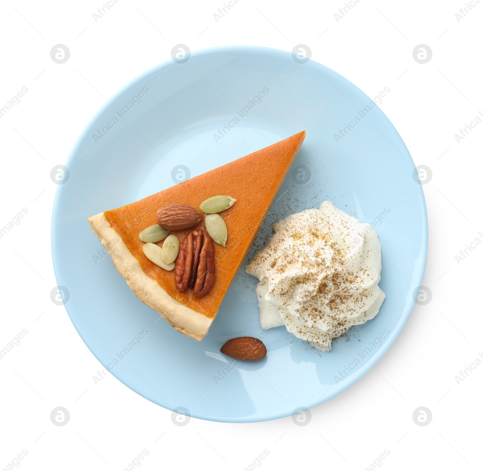 Photo of Piece of tasty homemade pumpkin pie with whipped cream, seeds and nuts isolated on white, top view