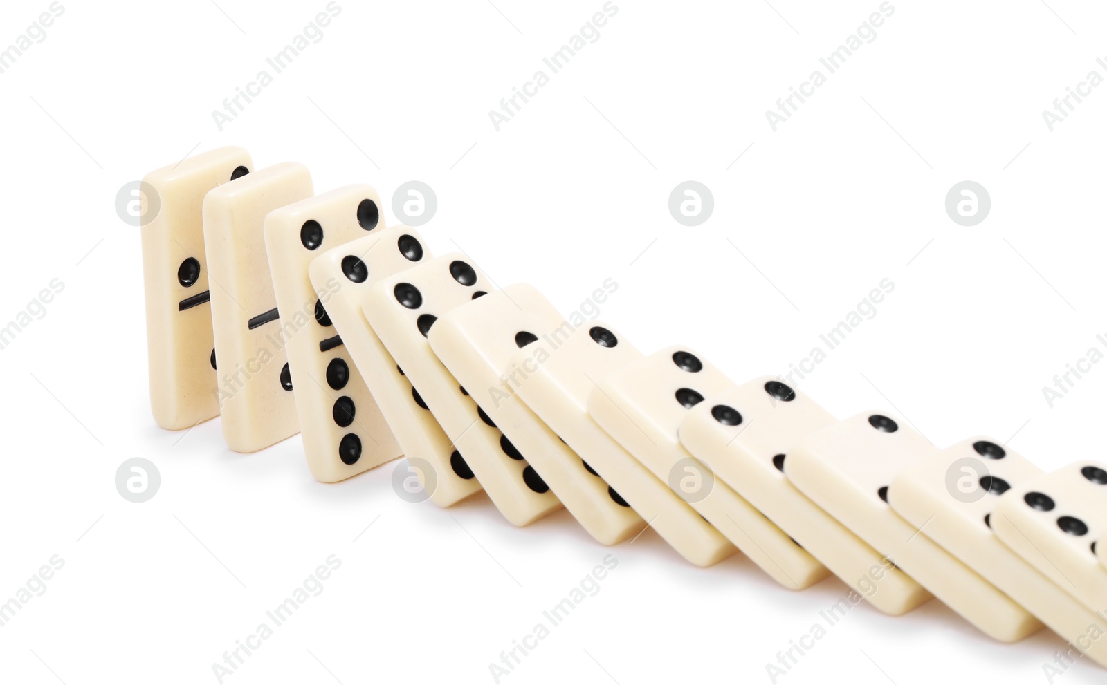 Photo of Domino effect. Tiles falling on white background