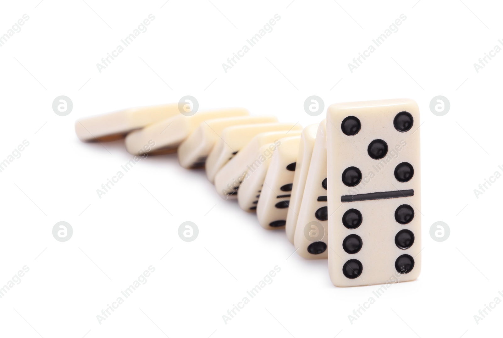 Photo of Domino effect. Tiles falling on white background