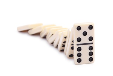 Photo of Domino effect. Tiles falling on white background