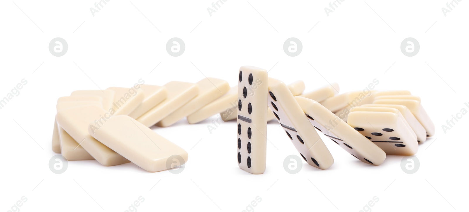 Photo of Domino effect. Tiles falling on white background