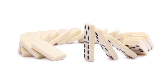 Photo of Domino effect. Tiles falling on white background