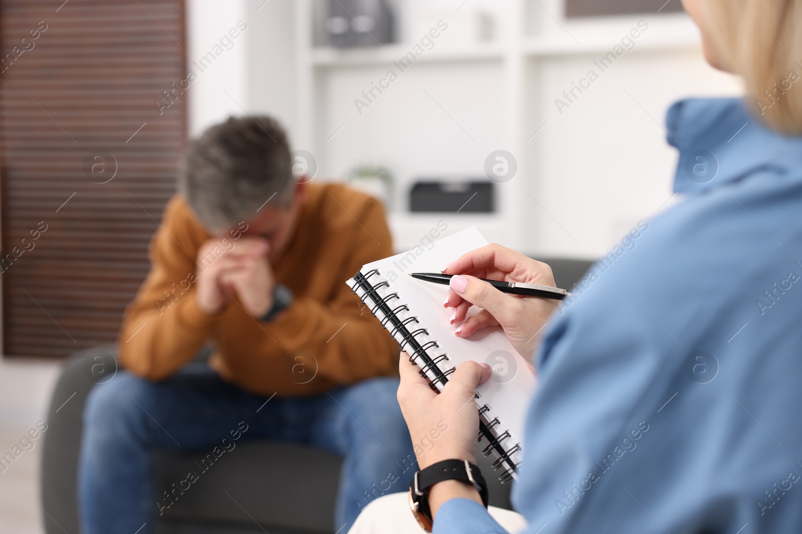 Photo of Professional psychologist working with patient in office, selective focus