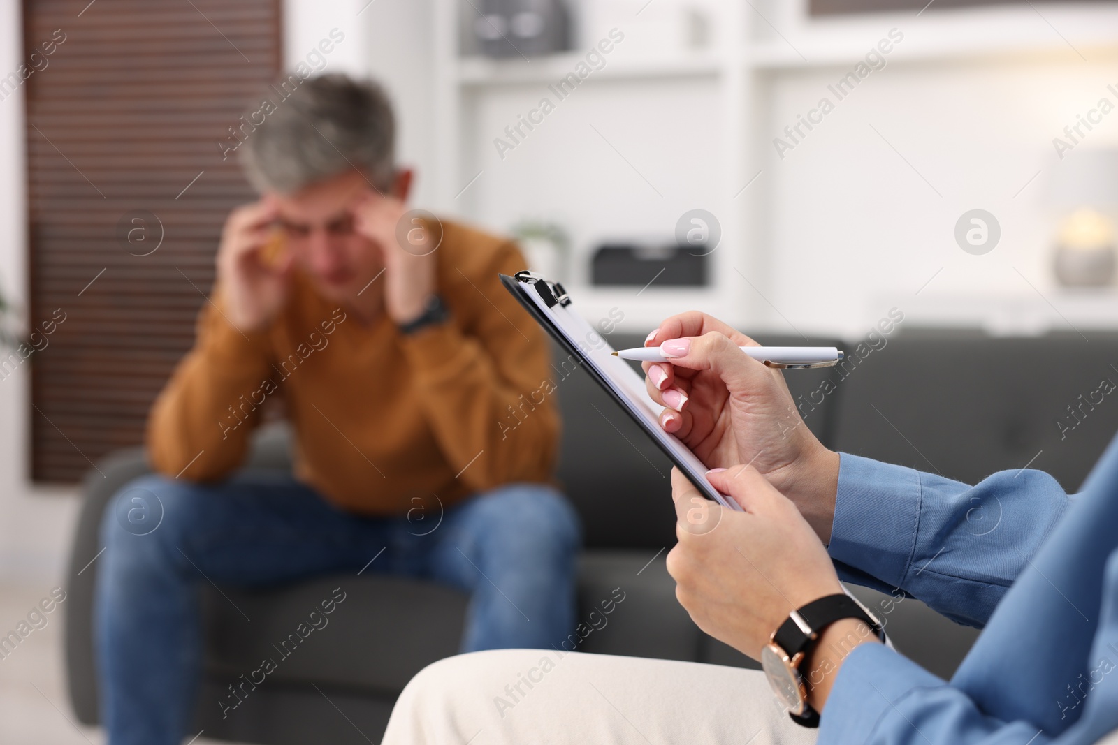 Photo of Professional psychologist working with patient in office, selective focus