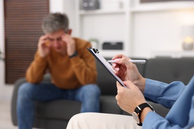 Photo of Professional psychologist working with patient in office, selective focus