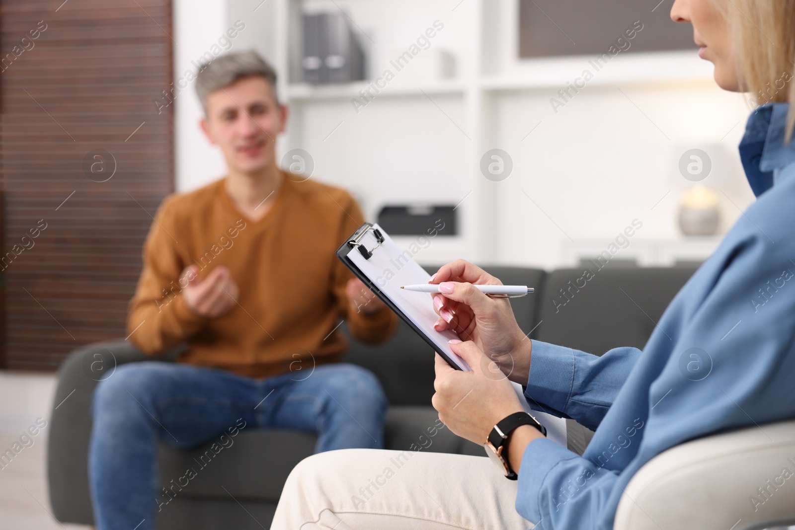 Photo of Professional psychologist working with patient in office, selective focus