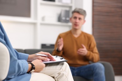 Photo of Professional psychologist working with patient in office, selective focus