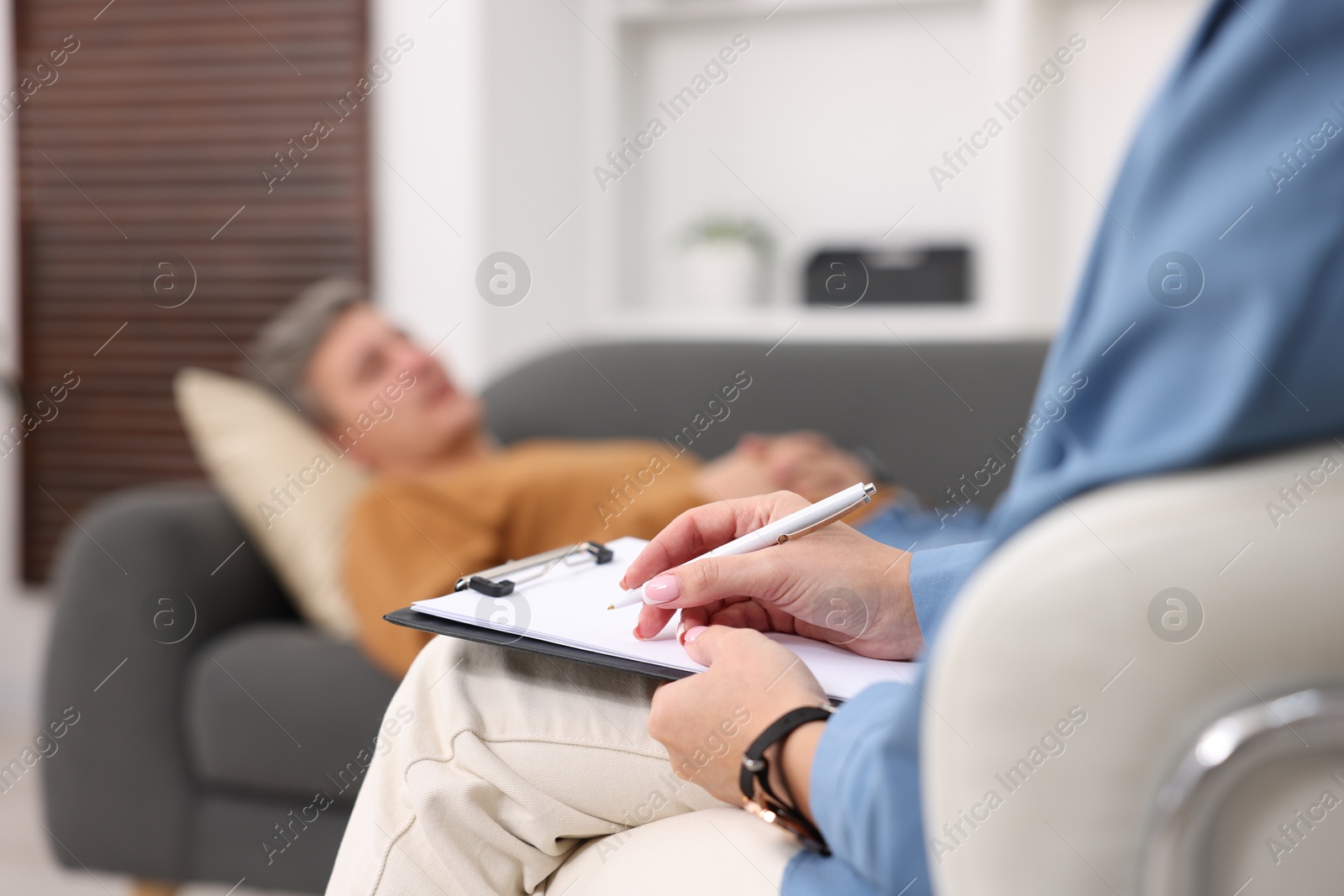 Photo of Professional psychologist working with patient in office, selective focus