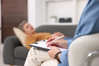 Photo of Professional psychologist working with patient in office, selective focus