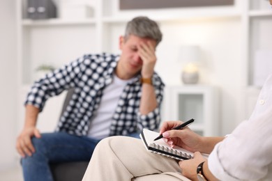 Photo of Professional psychologist working with patient in office, selective focus