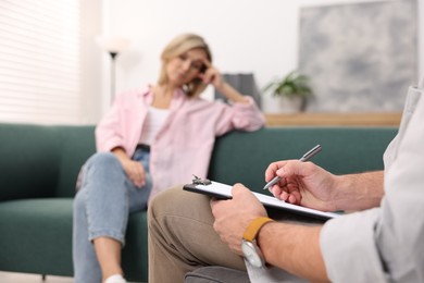 Photo of Professional psychologist working with patient in office, selective focus