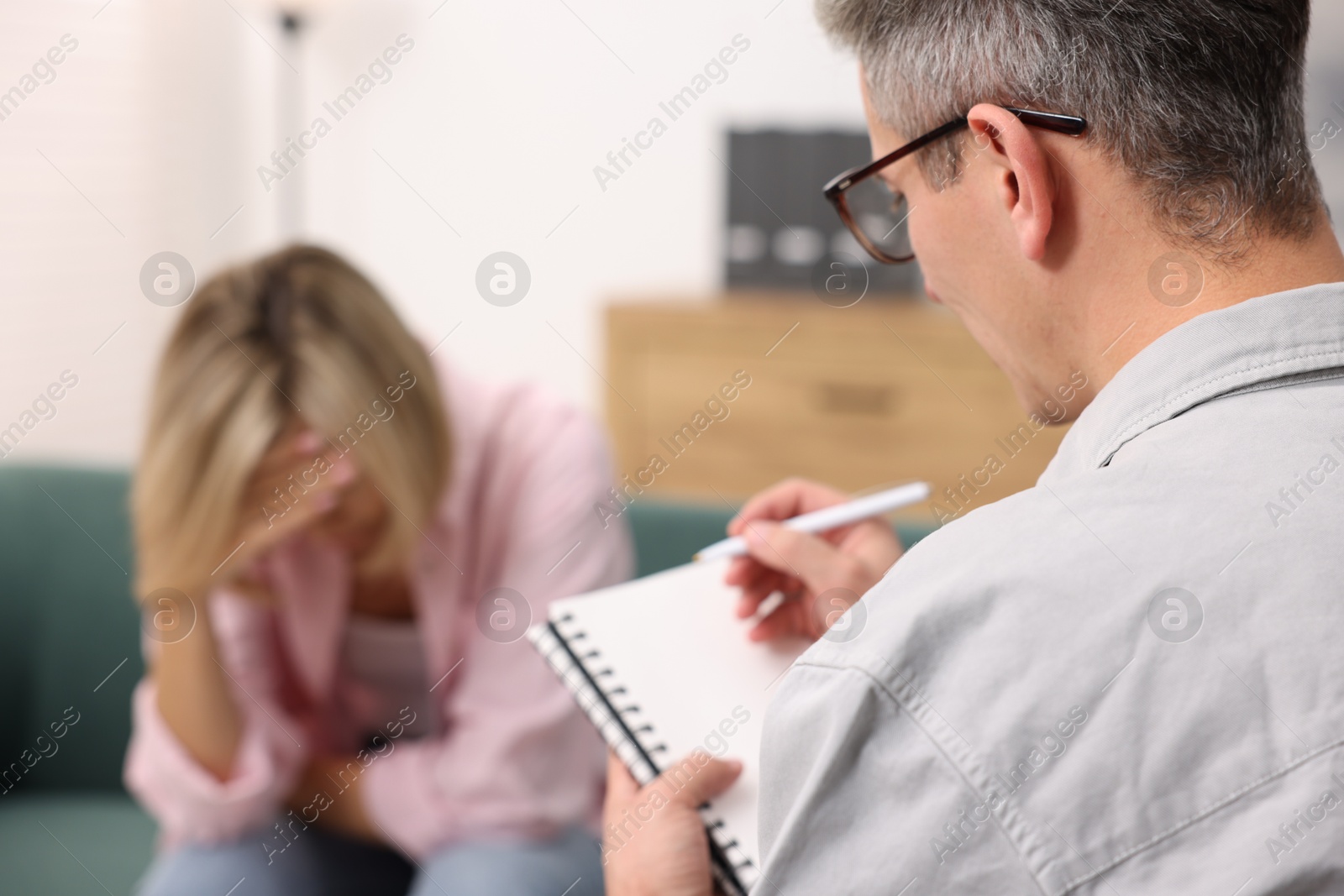 Photo of Professional psychologist working with patient in office, selective focus