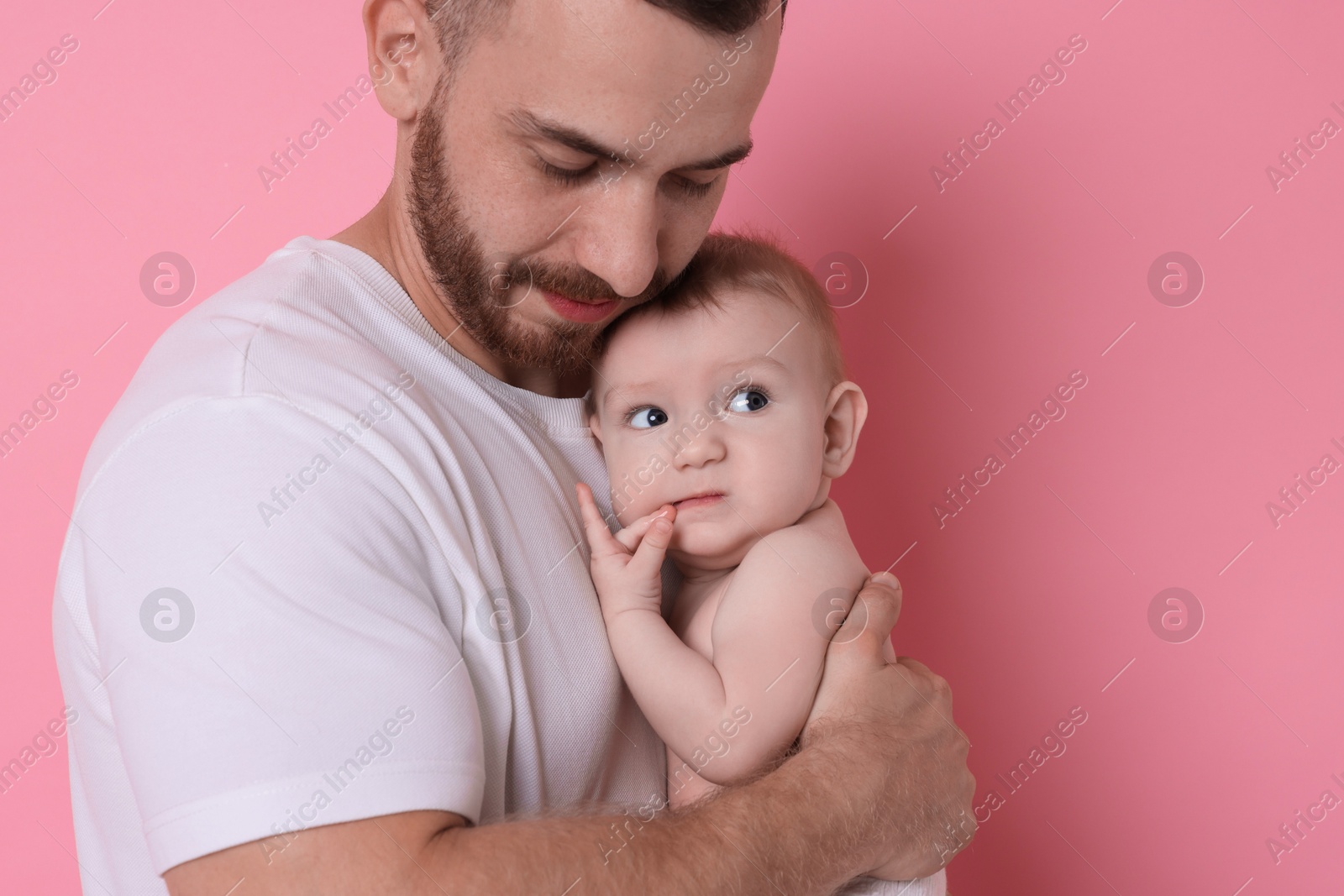 Photo of Father with his cute baby on pink background, space for text