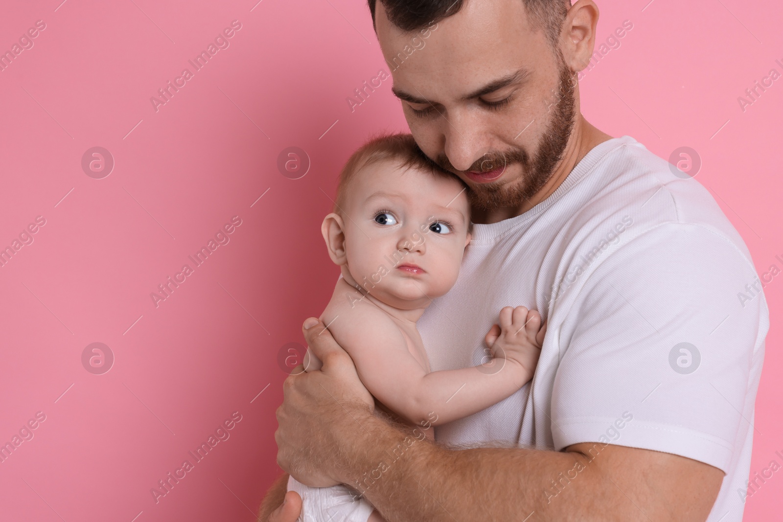 Photo of Father with his cute baby on pink background, space for text