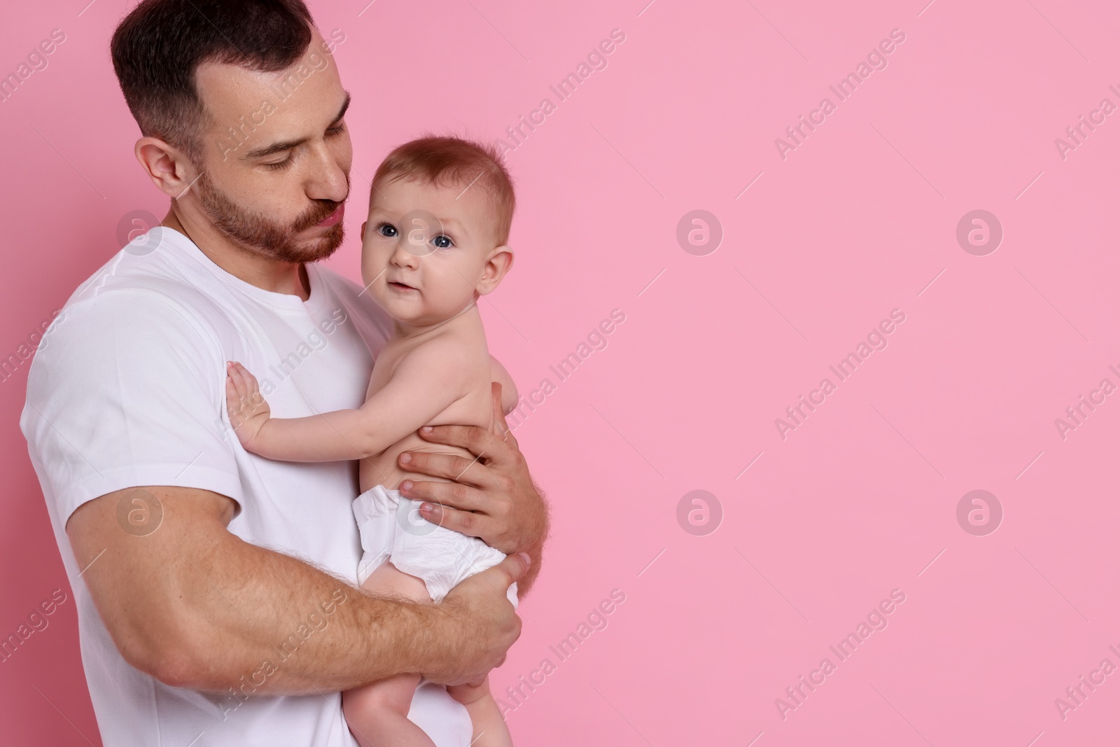 Photo of Father with his cute baby on pink background, space for text