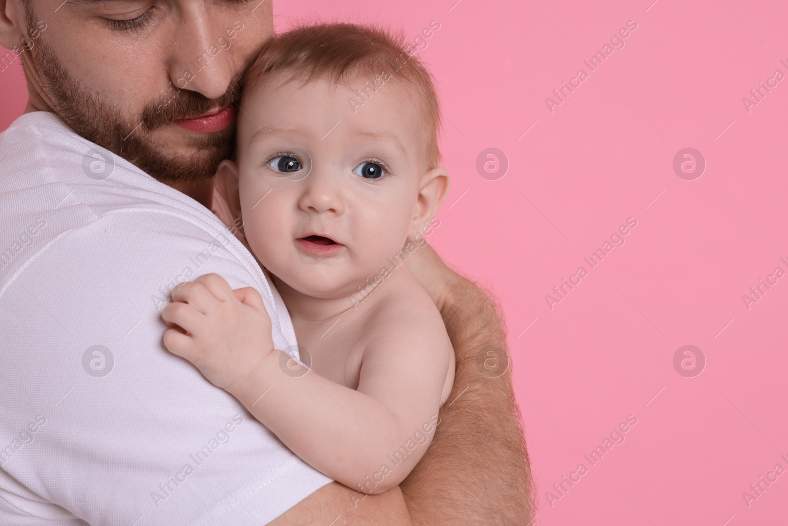 Photo of Father with his cute baby on pink background, space for text