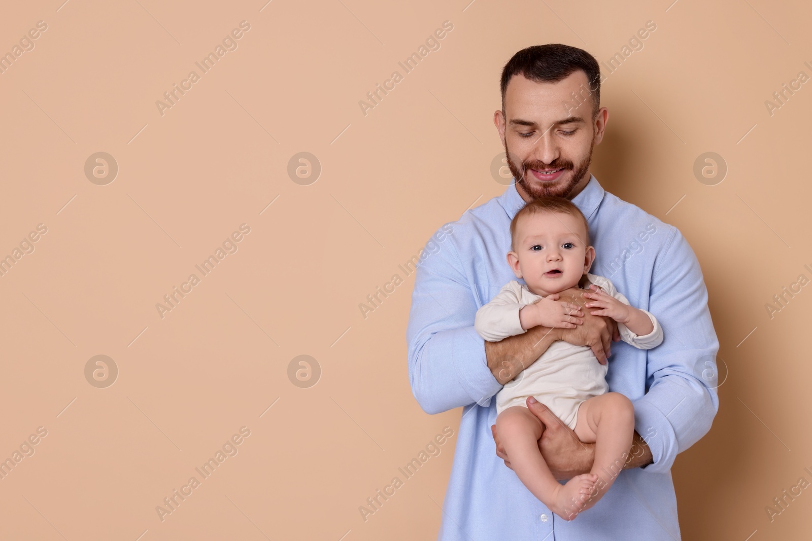 Photo of Father with his cute baby on beige background, space for text