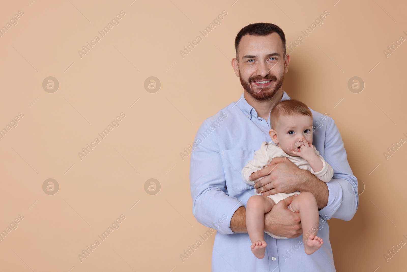 Photo of Father with his cute baby on beige background, space for text