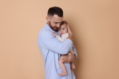 Photo of Father with his cute baby on beige background