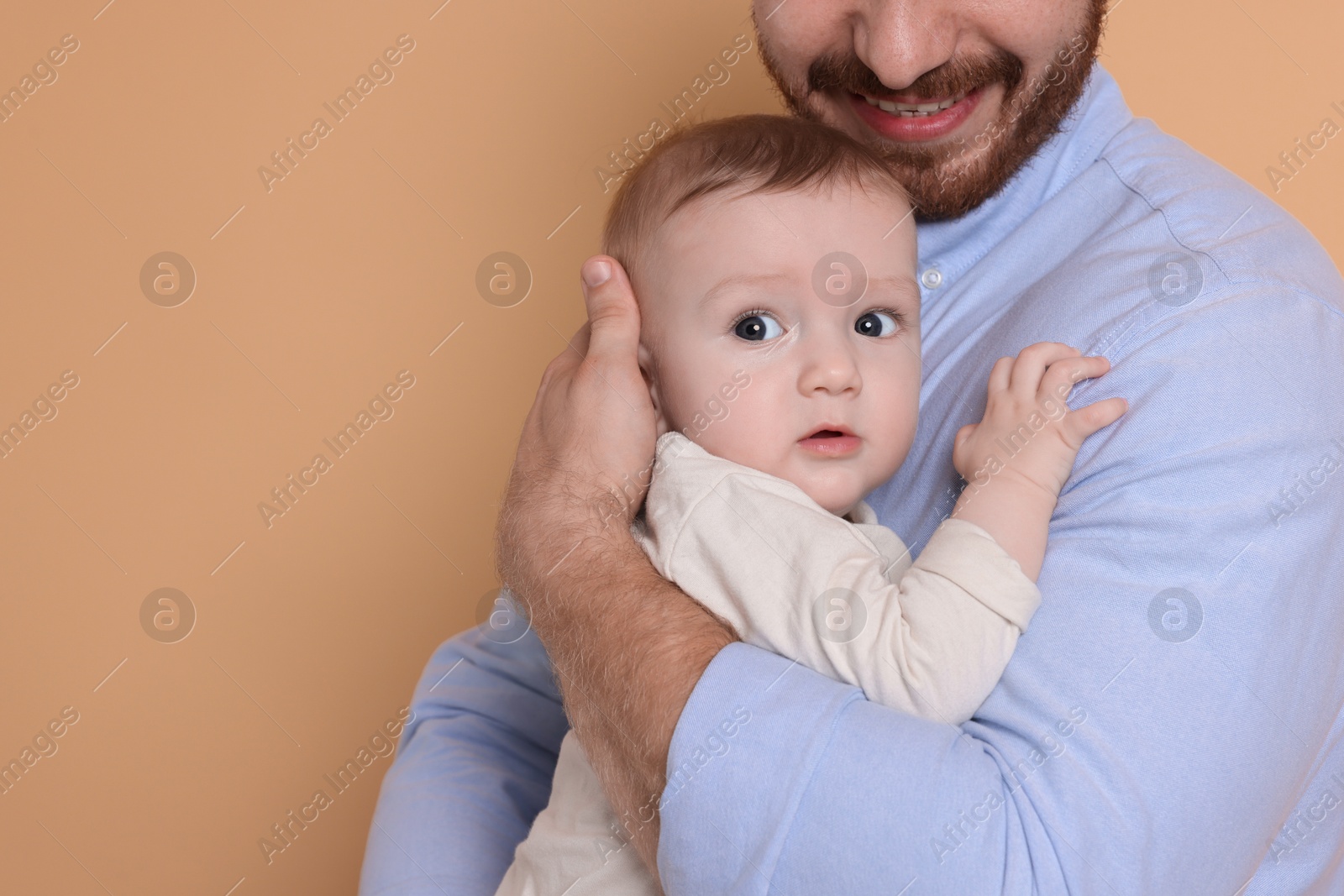 Photo of Father with his cute baby on beige background, space for text