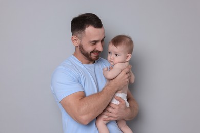 Photo of Father with his cute baby on grey background