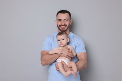 Photo of Father with his cute baby on grey background