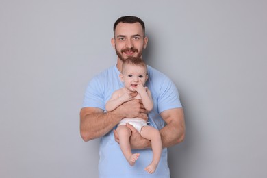 Photo of Father with his cute baby on grey background