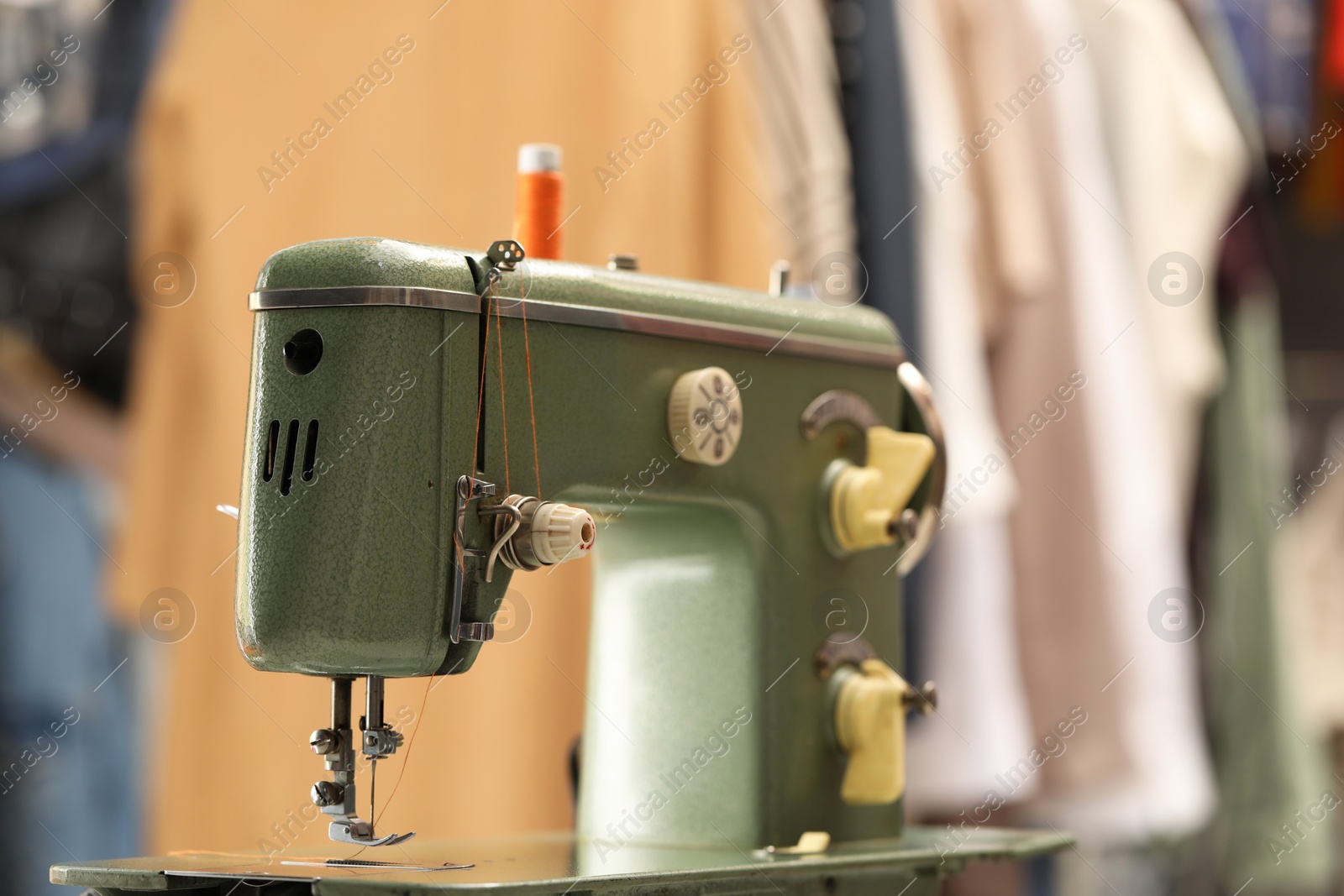 Photo of Vintage sewing machine with thread in workshop, closeup