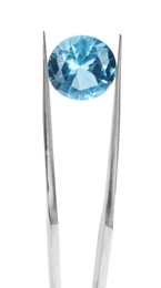 Photo of Tweezers with shiny light blue gemstone isolated on white