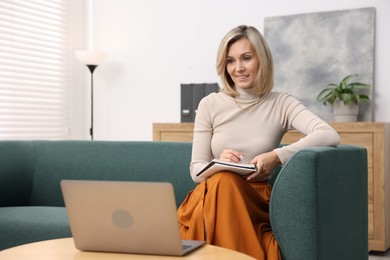 Photo of Professional psychologist working with notebook and laptop in office