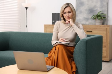 Professional psychologist working with notebook and laptop in office