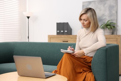 Photo of Professional psychologist working with notebook and laptop in office