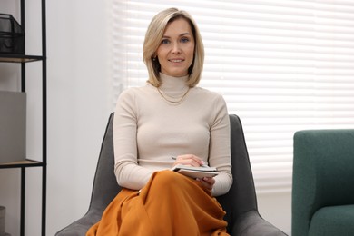 Photo of Portrait of professional psychologist with notebook in office