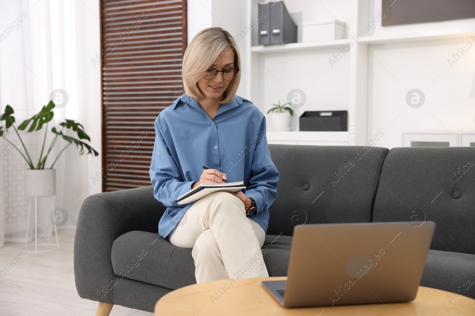 Photo of Professional psychologist working with laptop and notebook in office