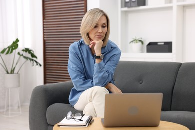 Photo of Professional psychologist working with laptop and notebook in office