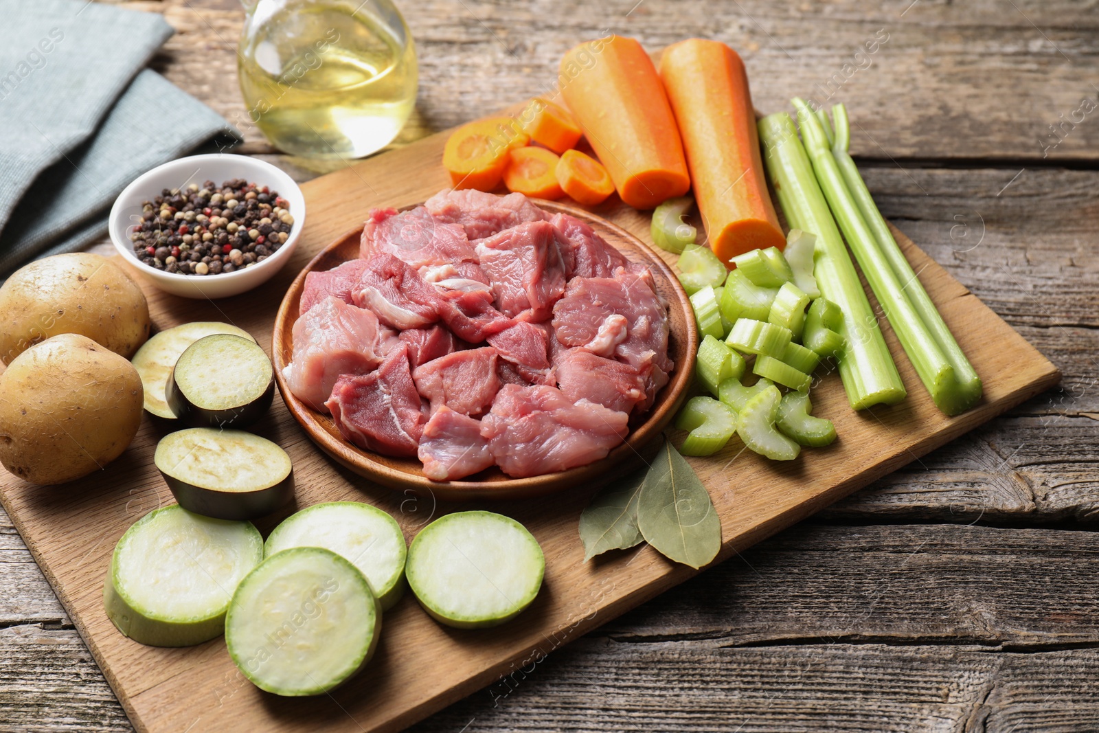 Photo of Cooking stew. Uncooked meat and vegetables on wooden table