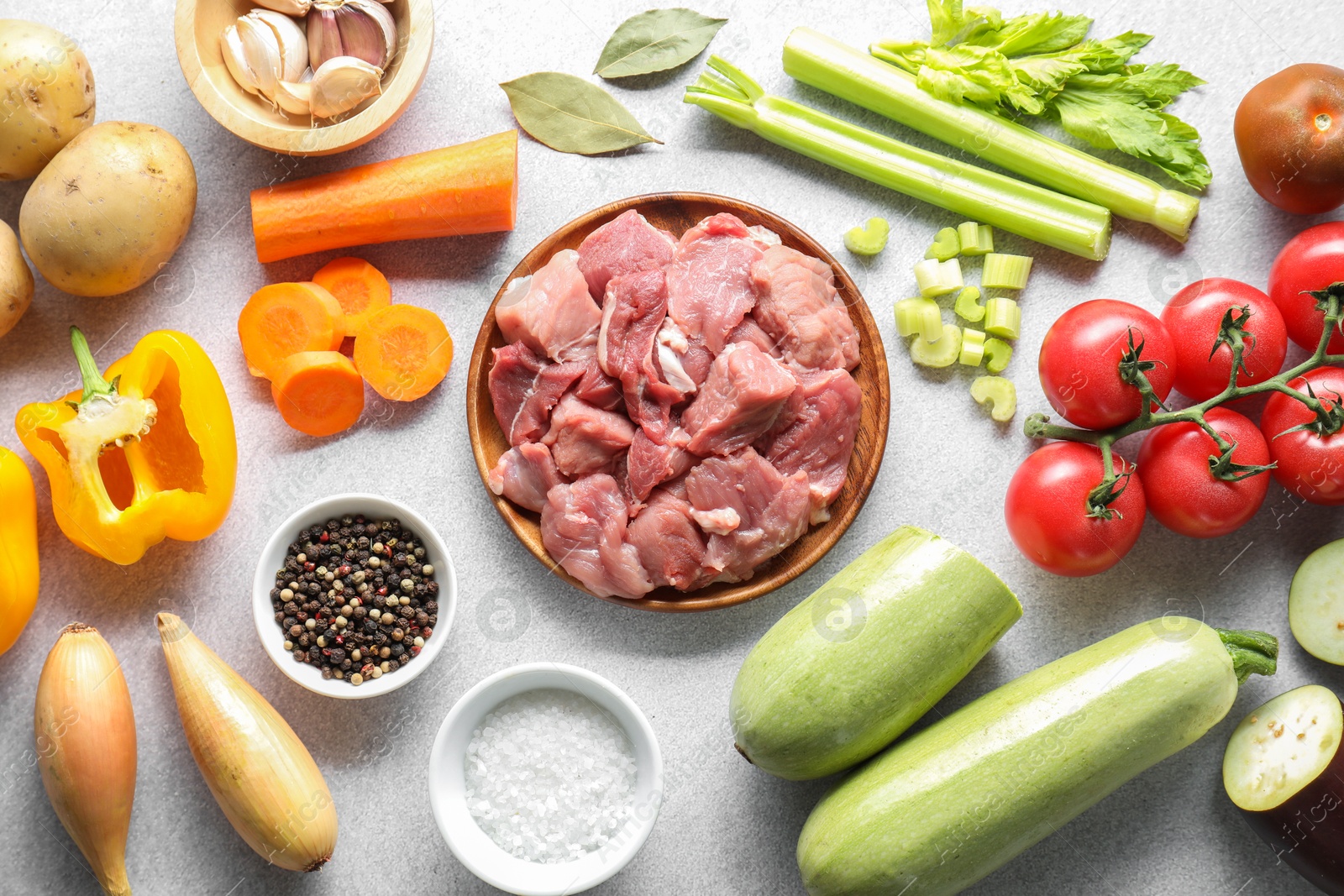 Photo of Cooking stew. Uncooked meat and vegetables on light grey table, flat lay