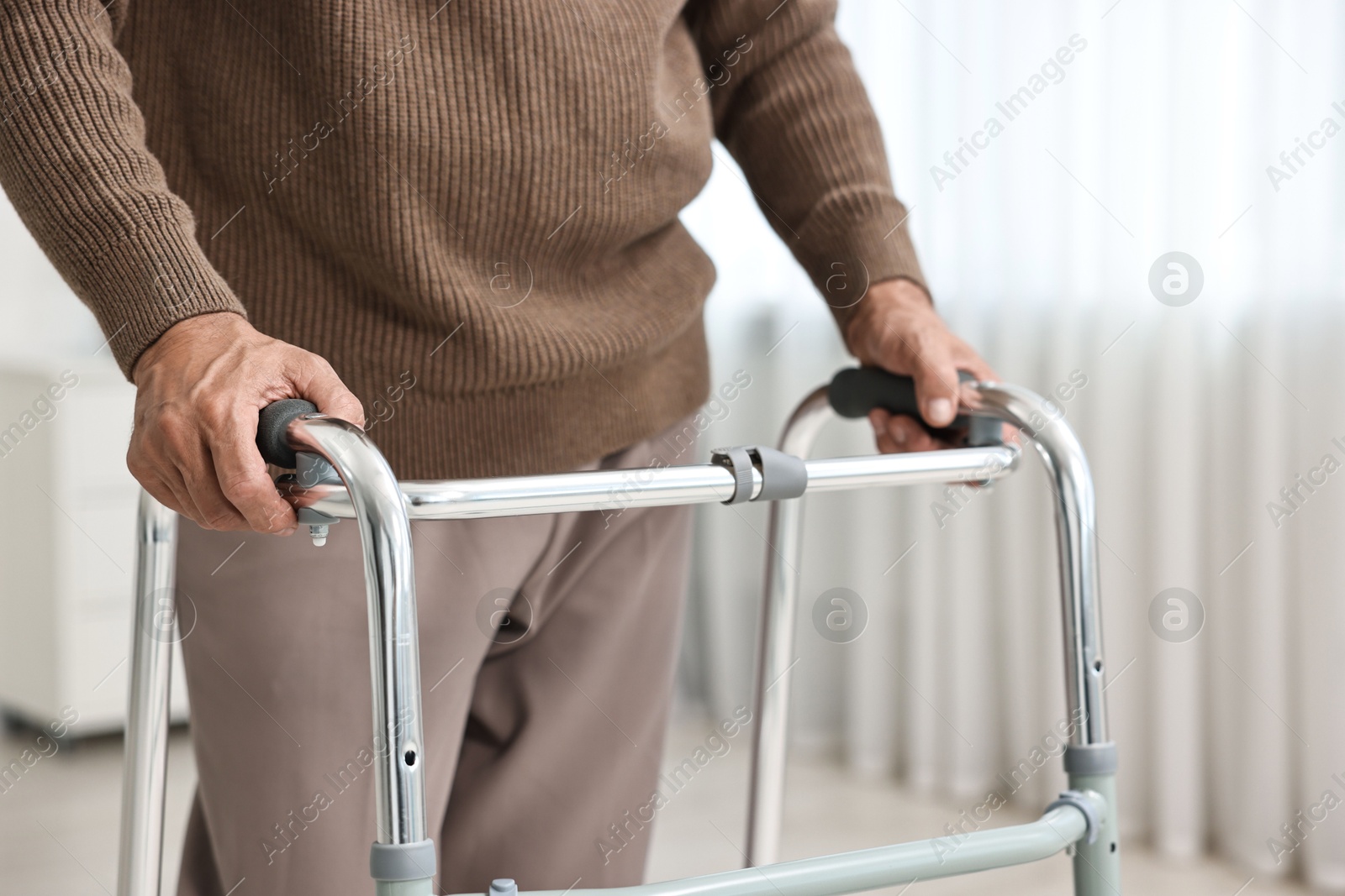 Photo of Senior man using walking frame at home, closeup