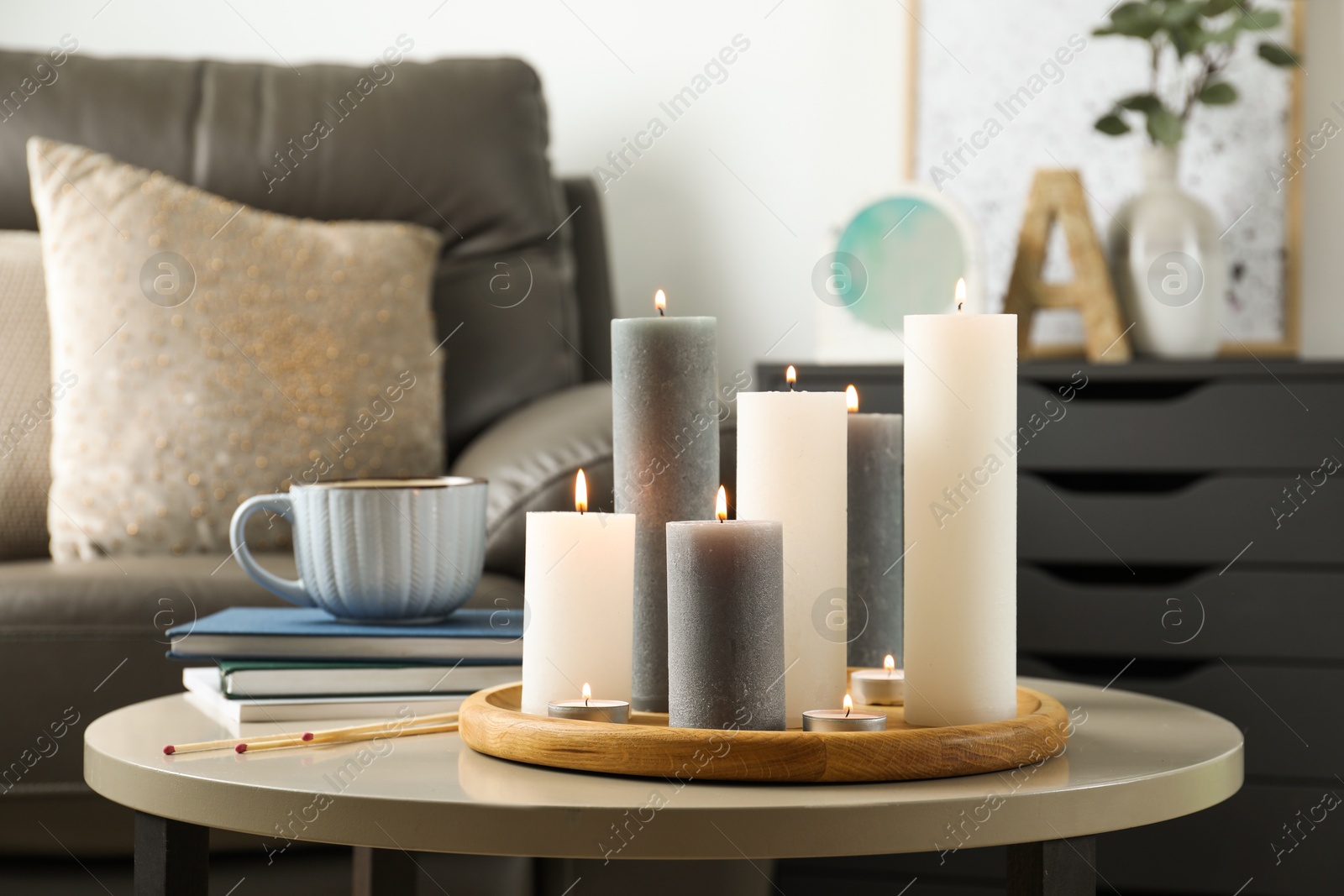 Photo of Beautiful burning candles and matches on light table indoors