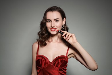 Photo of Smiling woman with red lipstick on grey background