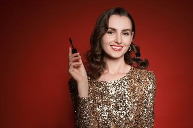 Photo of Smiling woman with makeup brush on red background. Space for text