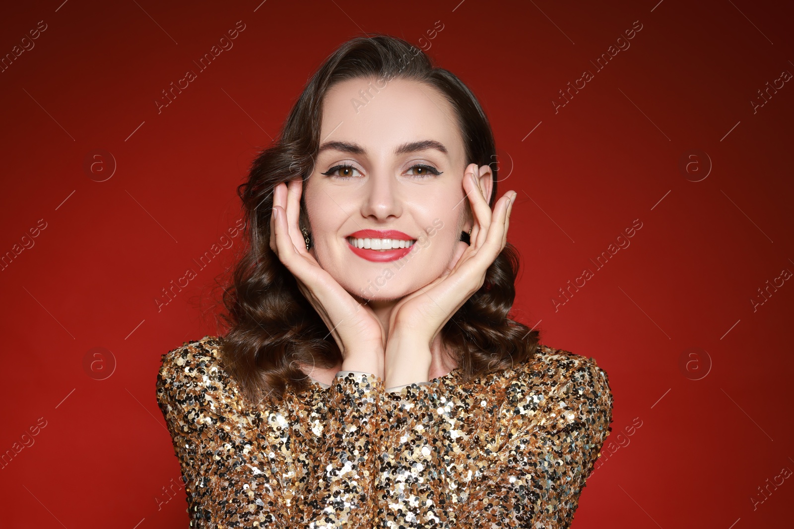 Photo of Smiling woman with perfect makeup on red background