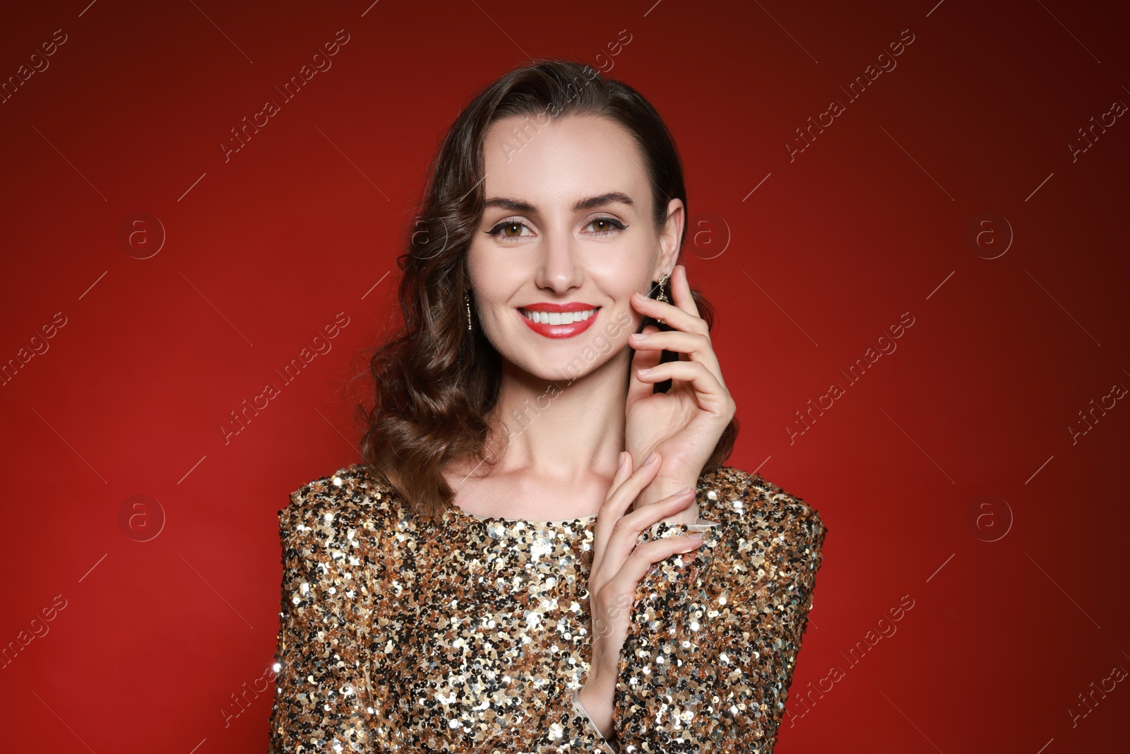 Photo of Smiling woman with perfect makeup on red background