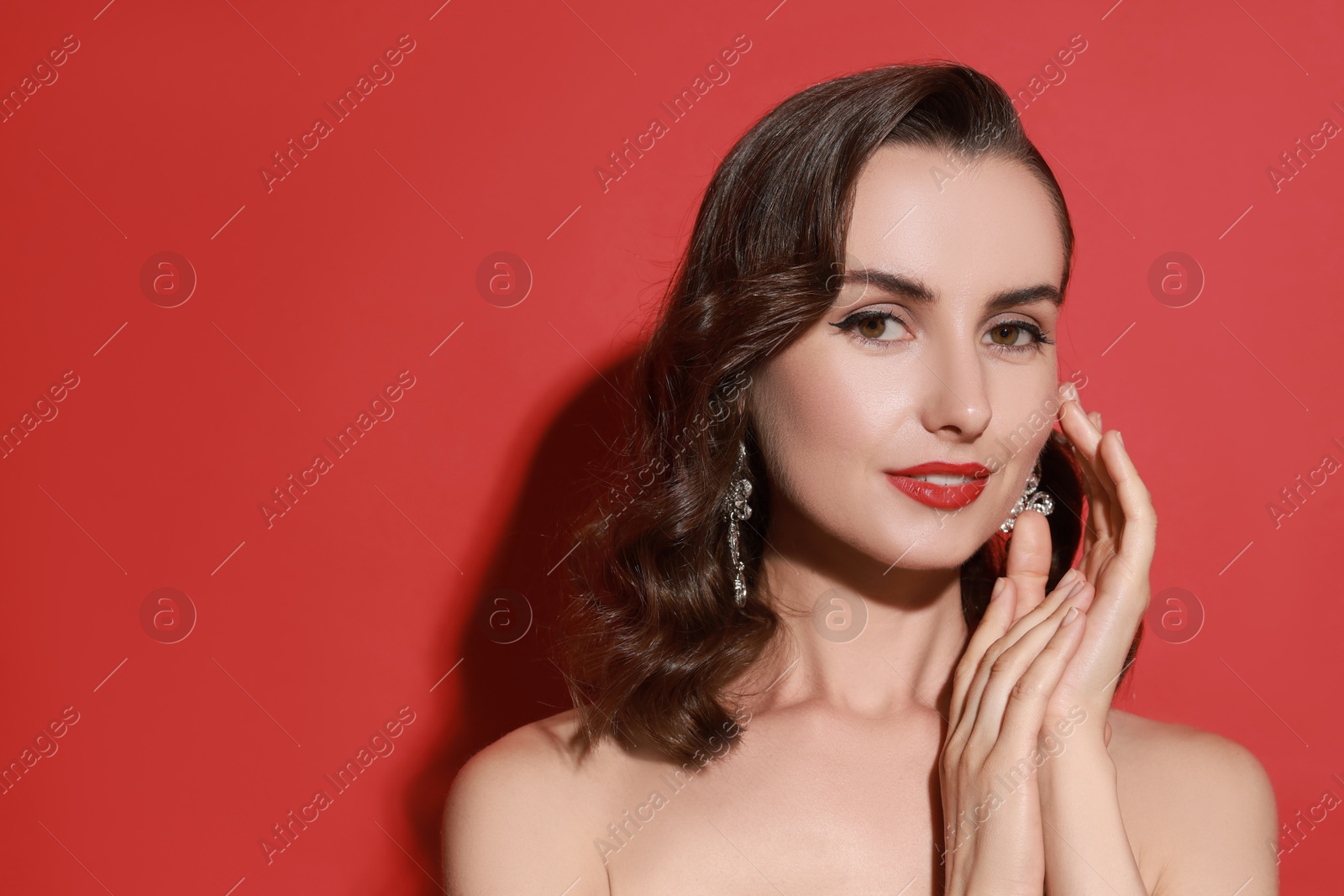 Photo of Woman with perfect makeup on red background. Space for text