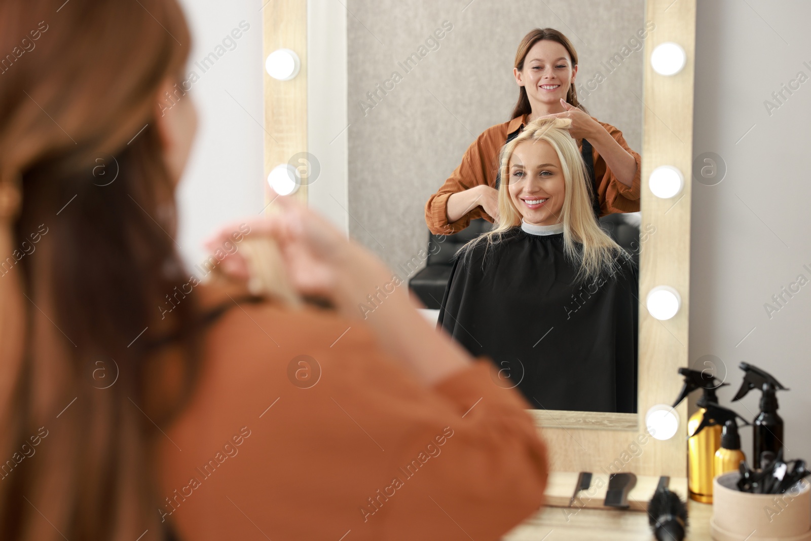 Photo of Hair cutting. Professional hairdresser working with client in salon, selective focus